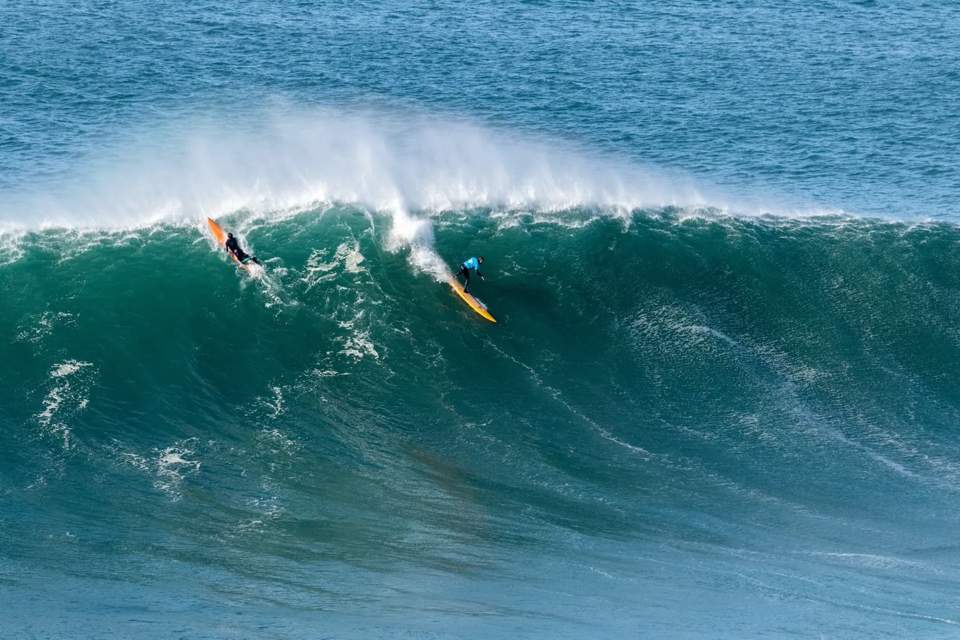Surfistas remando em onda grande